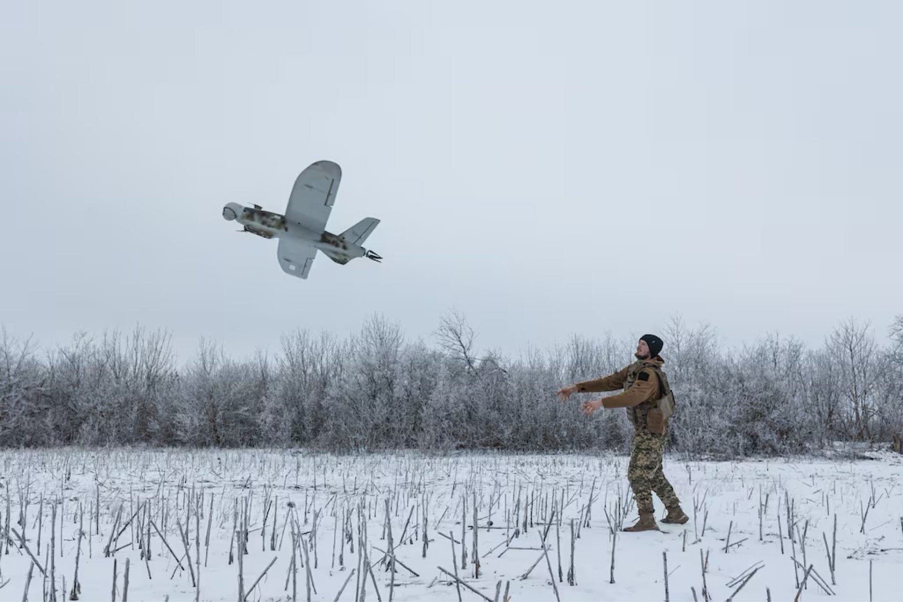 在積雪田野發射小型無人機的人員